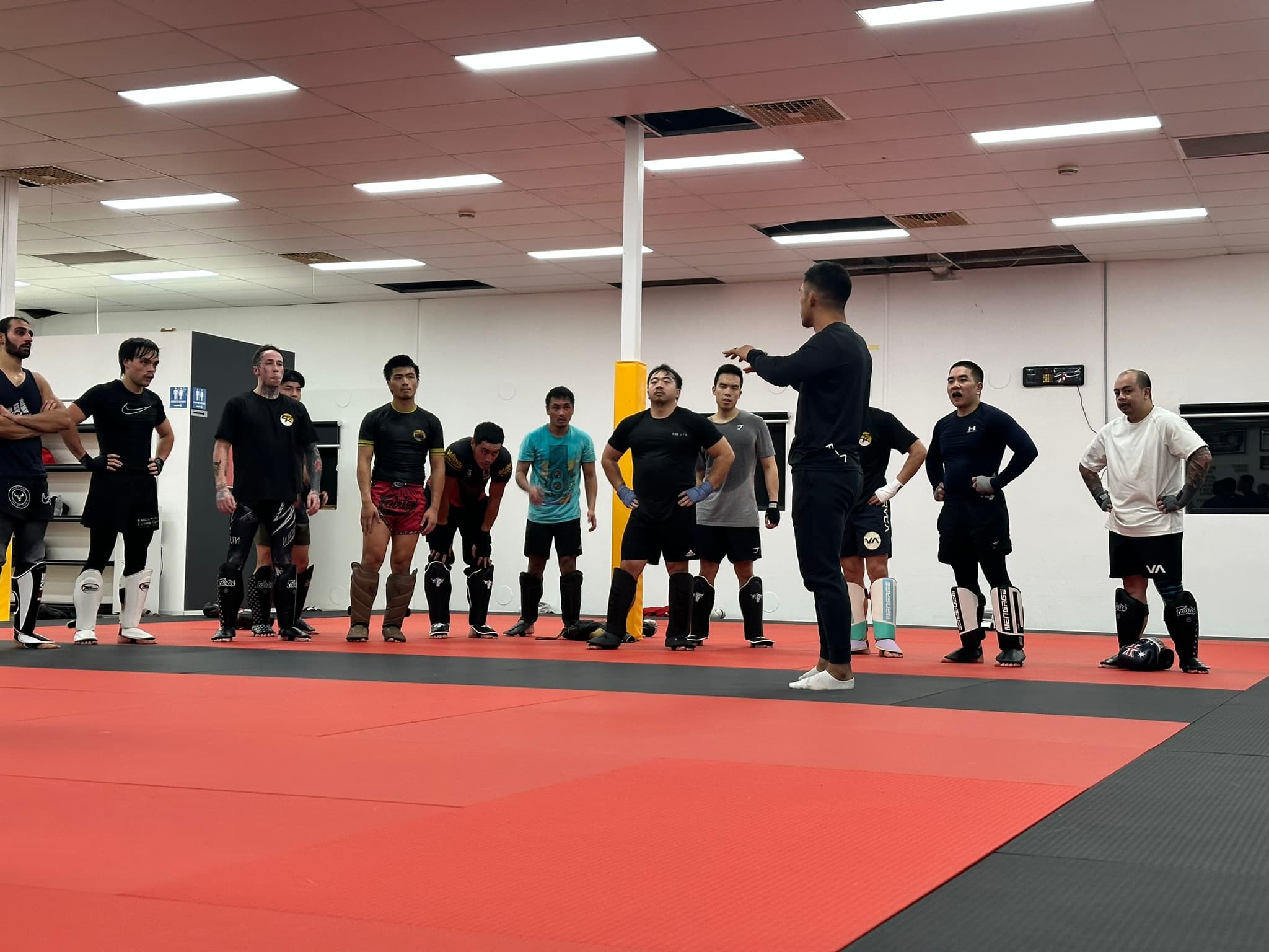 A coach briefing the class on the mats at Cabra Kai