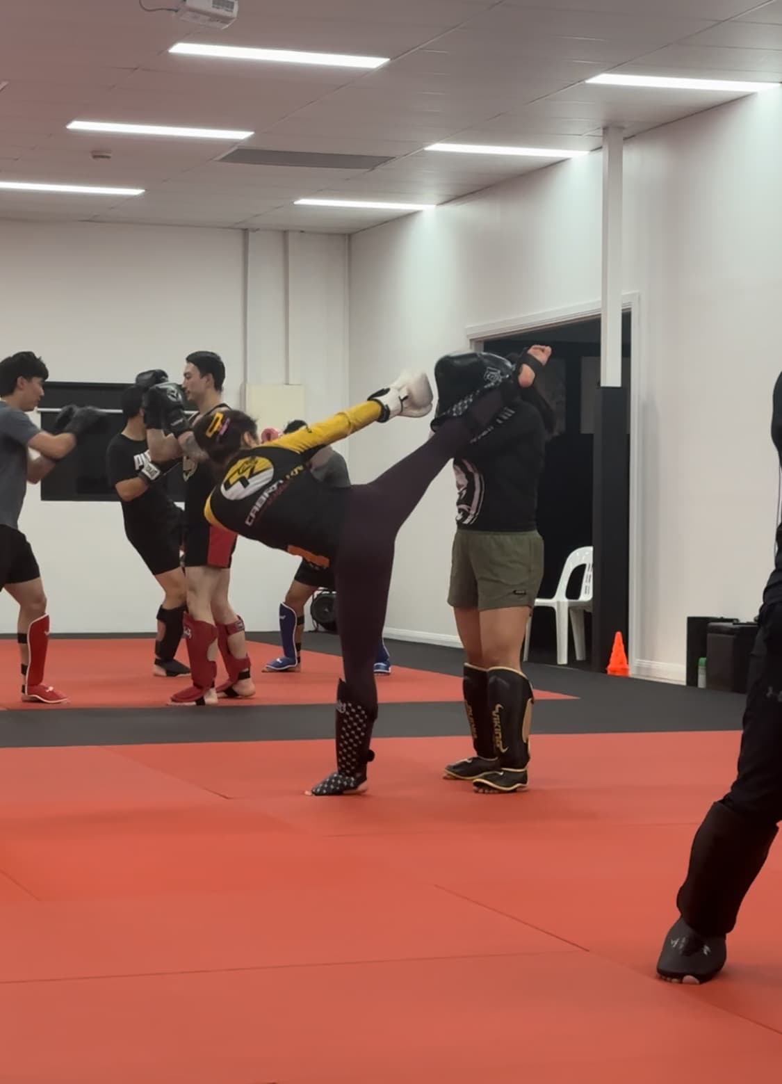 A high kick to the pads during kickboxing