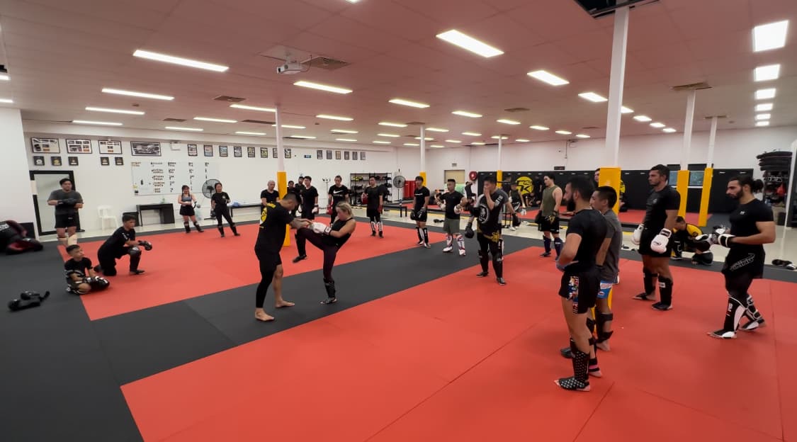 Kickboxing partners drilling a roundhouse kick during class